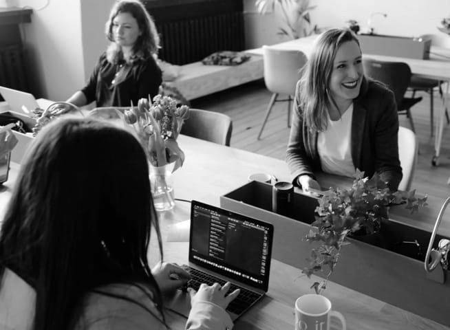 workplace with young women siting at the desk and smiling